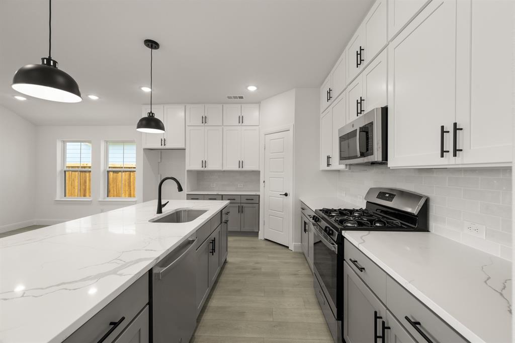 408 Dylan Way Midlothian, TX 76065 - Photo 30 of 40 a kitchen with stainless steel appliances granite countertop a sink a stove and a refrigerator