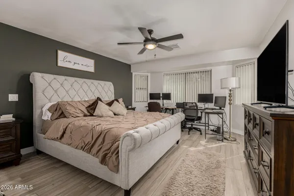 a spacious bedroom with a bed and a flat screen tv