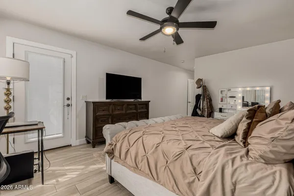 a bedroom with a bed and a flat tv screen on a dresser