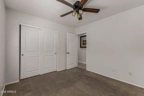 an empty room with windows and fan