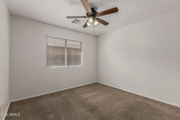 an empty room with a window and a fan
