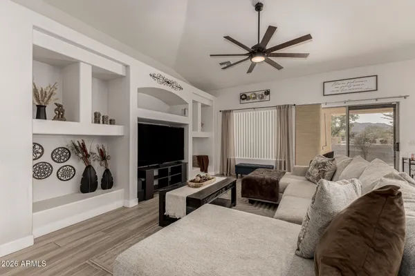 a living room with furniture a flat screen tv and a window