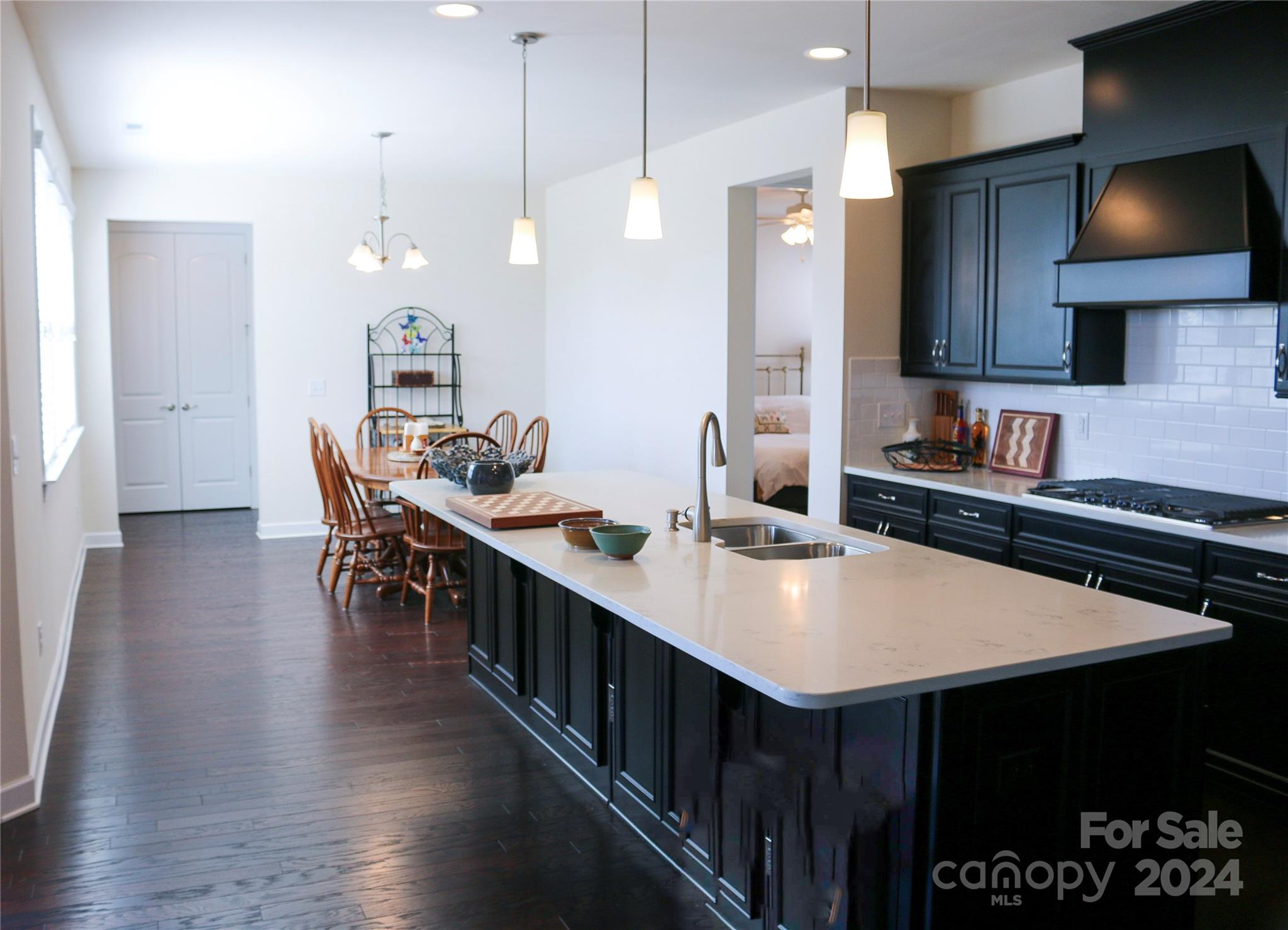 1296 Independence Street Tega Cay, SC 29708 - Photo 4 of 28 a kitchen with stainless steel appliances a table chairs sink and stove
