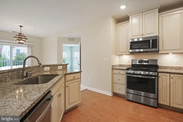 a kitchen with granite countertop a sink and a stove top oven