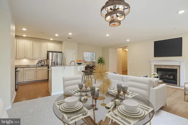 a living room with dining table furniture a fireplace and kitchen view