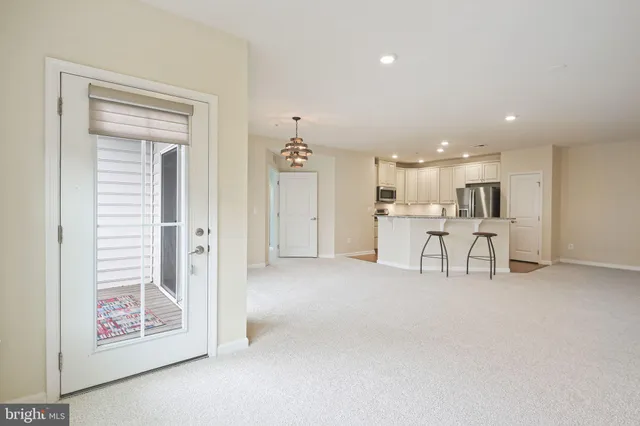 a view of a kitchen with refrigerator and white cabinets