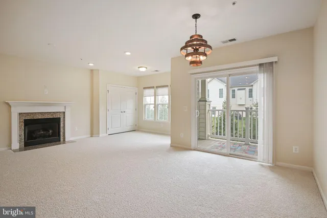 a view of an empty room with a fireplace and a window