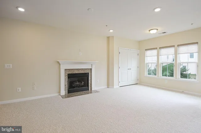 a view of an empty room with a window and a fireplace