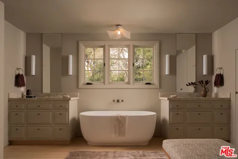 a spacious bathroom with a tub sink and mirror