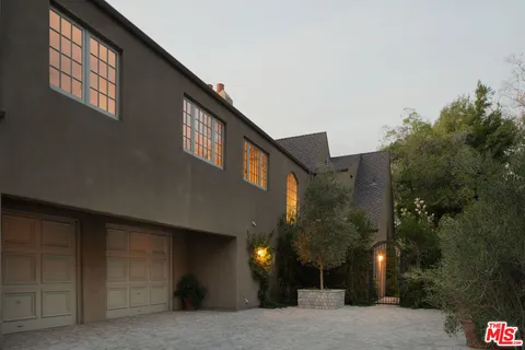 a view of a white house with a yard table and chairs