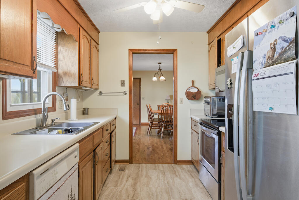 6389 Ruebush Road Dublin, VA 24084 - Photo 19 of 63 a kitchen with a sink dishwasher a refrigerator and a stove with wooden floor