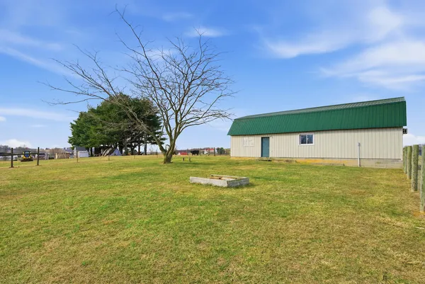 a view of a house with backyard and trees