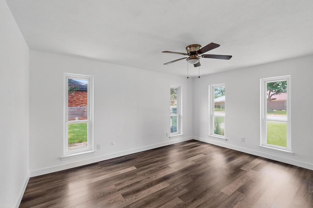 4857 Fallon Place Dallas, TX 75227 - Photo 15 of 19 Unfurnished room with dark wood-style floors, healthy amount of natural light, and a ceiling fan