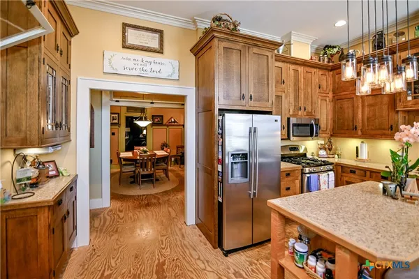 a kitchen with stainless steel appliances granite countertop a refrigerator and a stove