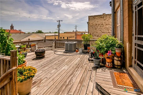 a view of a patio with couches table and chairs and potted plants