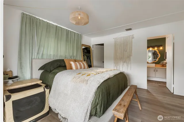 a bed sitting in a spacious bedroom next to a window