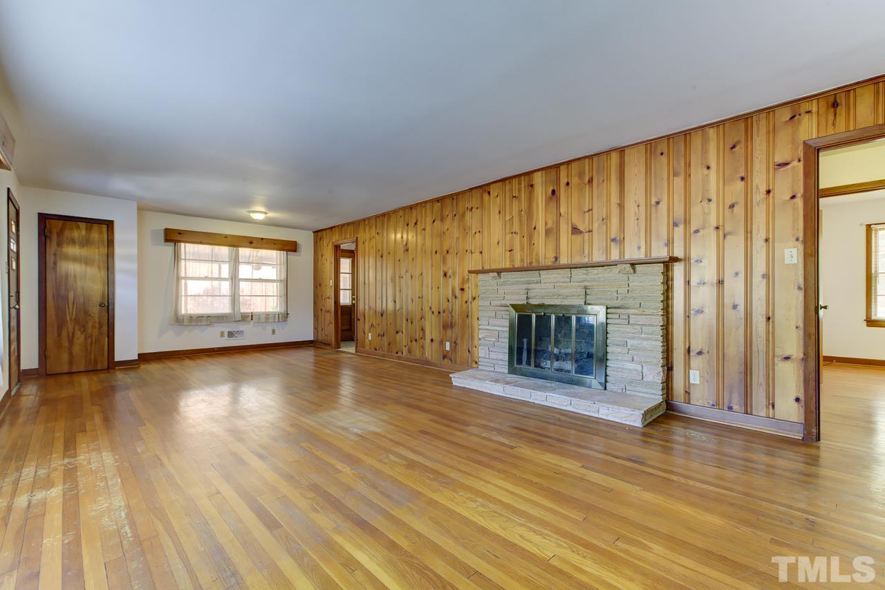 3912 Buffaloe Road Raleigh, NC 27604 - Photo 2 of 8 an empty room with wooden floor and fireplace
