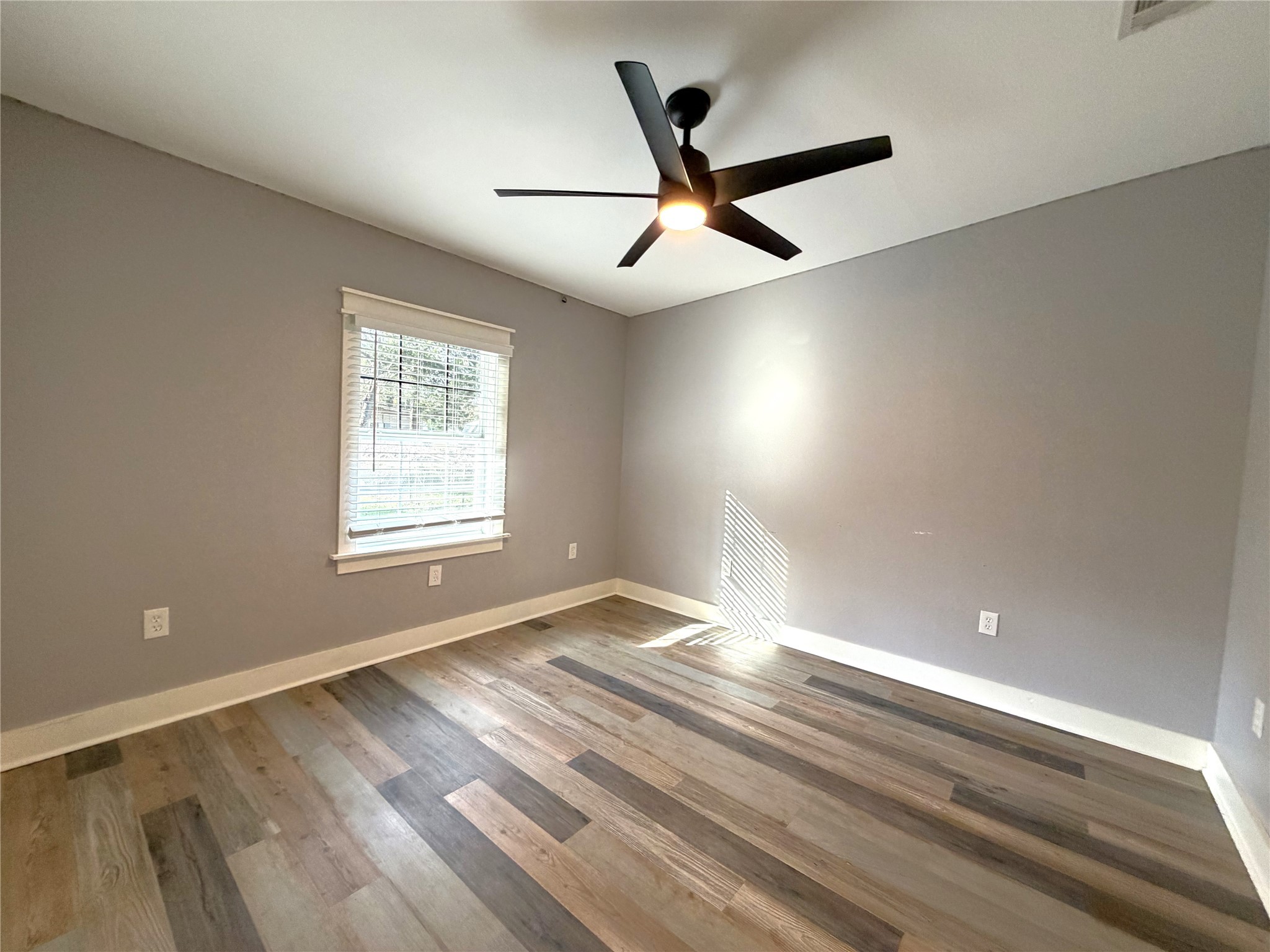 410 North Elm Street Trinity, TX 75862 - Photo 19 of 20 an empty room with wooden floor fan and windows