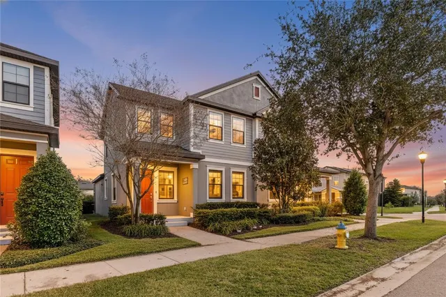 a front view of a house with garden and trees