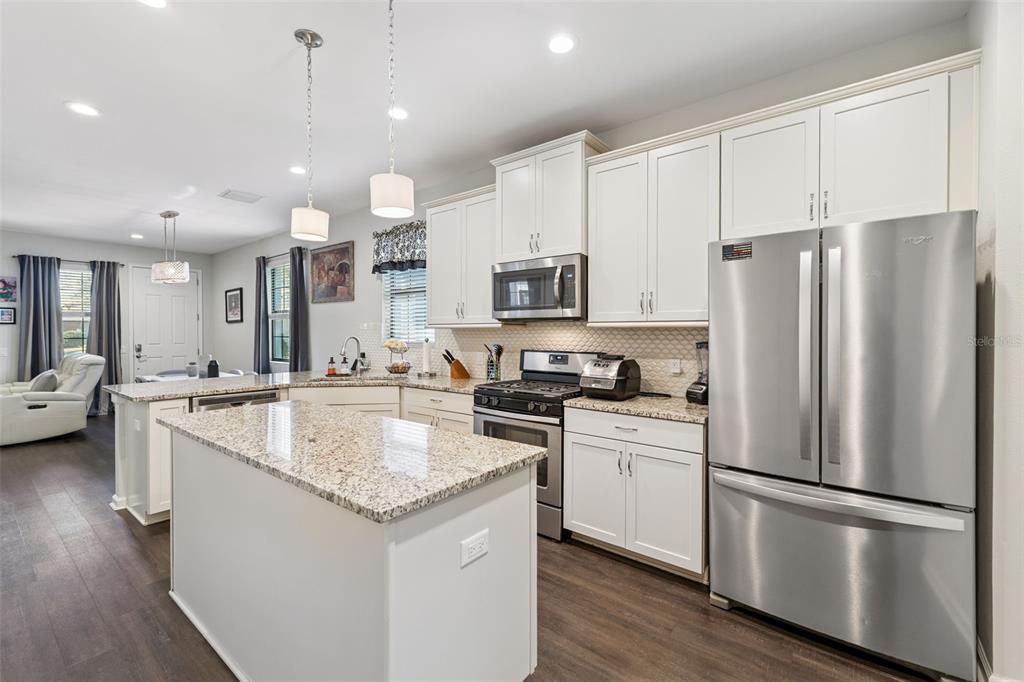 5714 Colony Glen Road Lithia, FL 33547 - Photo 11 of 66 a kitchen with stainless steel appliances granite countertop a refrigerator a sink and a stove top oven