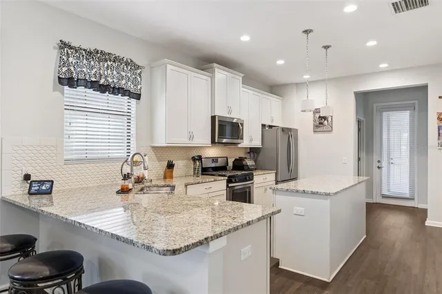a kitchen with granite countertop a sink a stove and cabinets