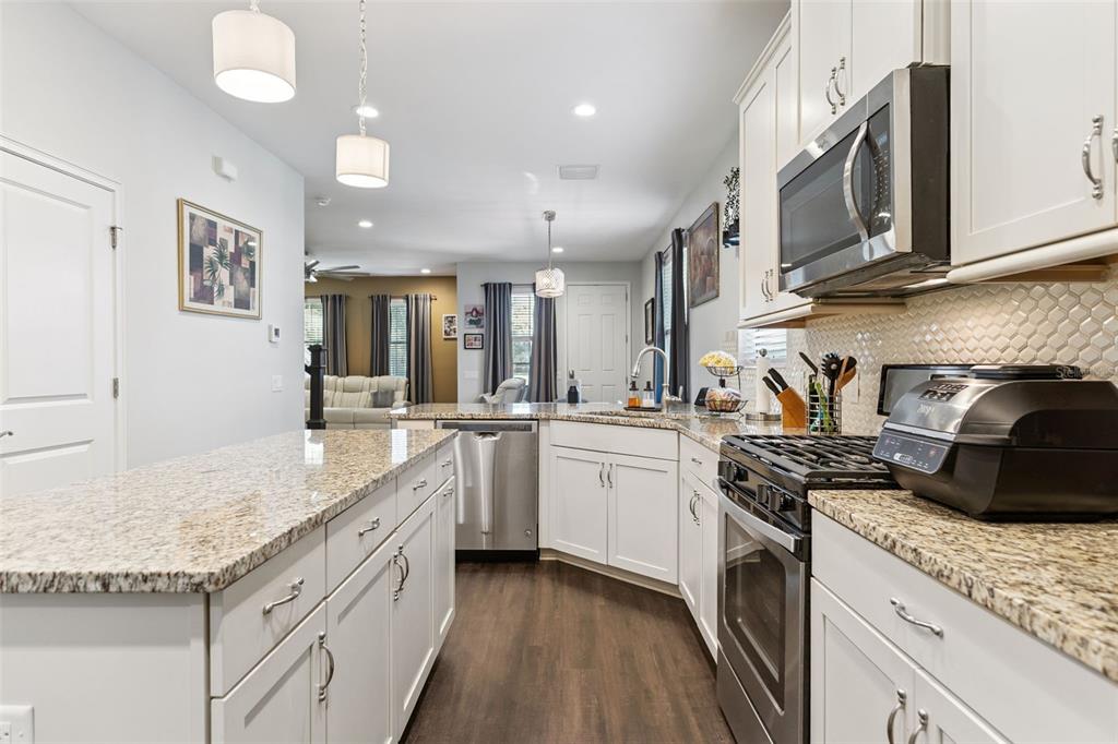 5714 Colony Glen Road Lithia, FL 33547 - Photo 10 of 66 a kitchen with granite countertop a sink a stove and cabinets