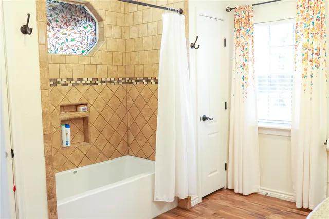 a bathroom with a bathtub and shower