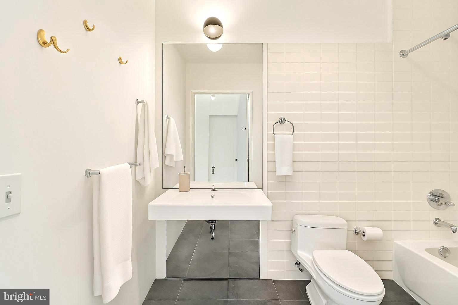 1600 Arch Street, Unit 1809 Philadelphia, PA 19103 - Photo 11 of 36 a bathroom with a toilet a sink and a mirror