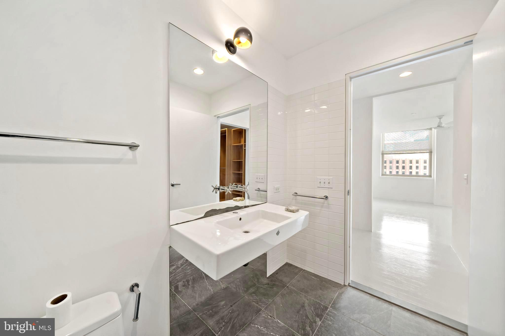 1600 Arch Street, Unit 1809 Philadelphia, PA 19103 - Photo 13 of 36 a bathroom with a sink a mirror and a shower