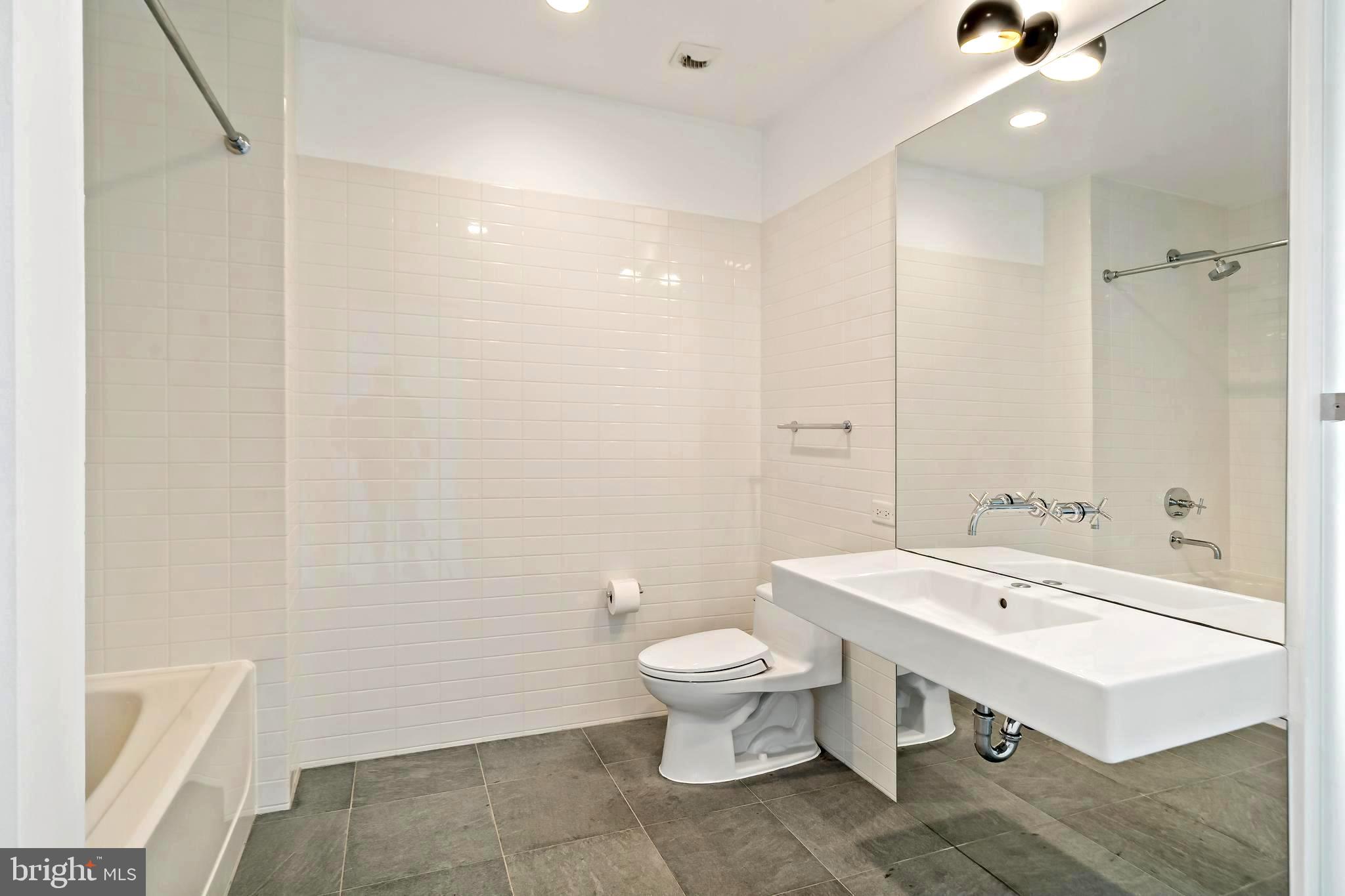 1600 Arch Street, Unit 1809 Philadelphia, PA 19103 - Photo 24 of 36 a bathroom with a sink a toilet and a large mirror