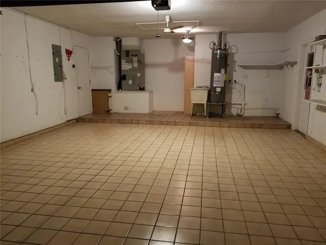 an empty room with kitchen and chandelier