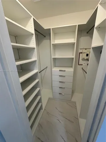 a view of walk in closet with empty racks