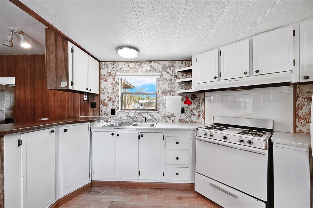 123 Miller Road Pomona Park, FL 32181 - Photo 22 of 36 a kitchen with granite countertop white cabinets and white appliances