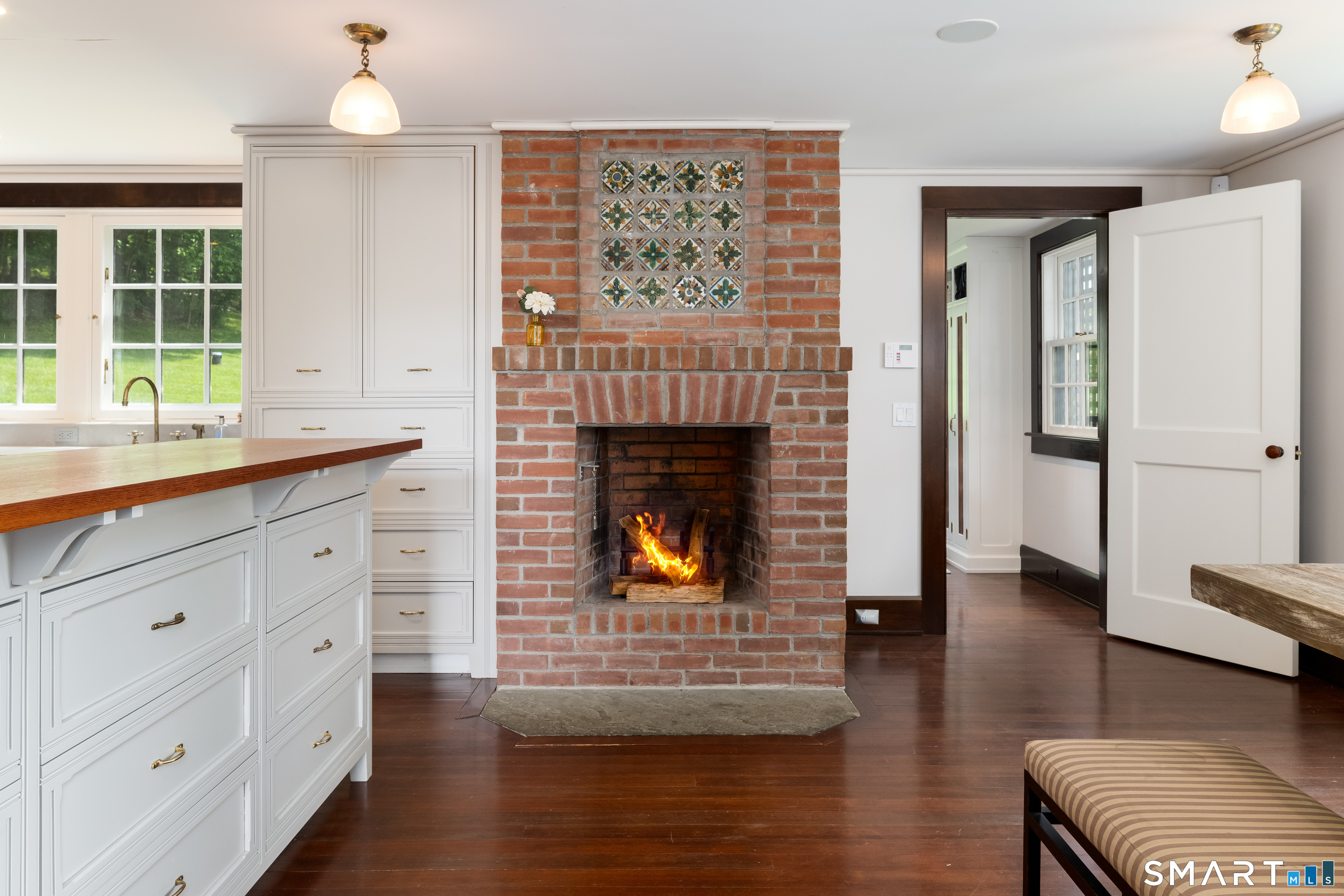 240 Umpawaug Road Redding, CT 06896 - Photo 12 of 40 Casual dining area with wood-burning brick fireplace enhanced by the charming original tiles inset above.