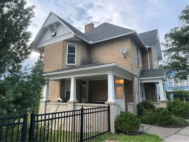 a view of house with a yard and large tree