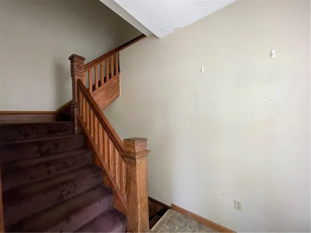a view of staircase with wooden floor and white walls