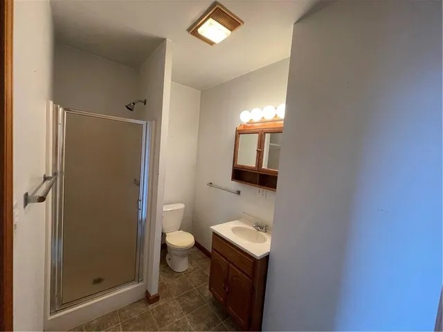 a bathroom with a sink a toilet and shower