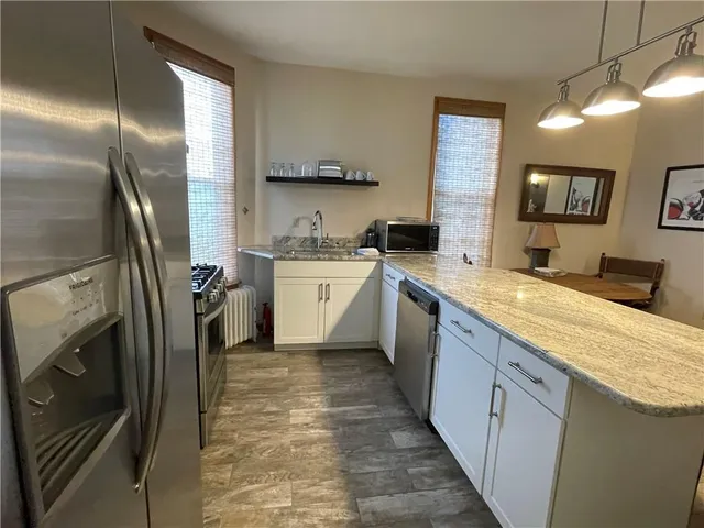 a large kitchen with stainless steel appliances granite countertop a sink a stove a washer dryer and a refrigerator