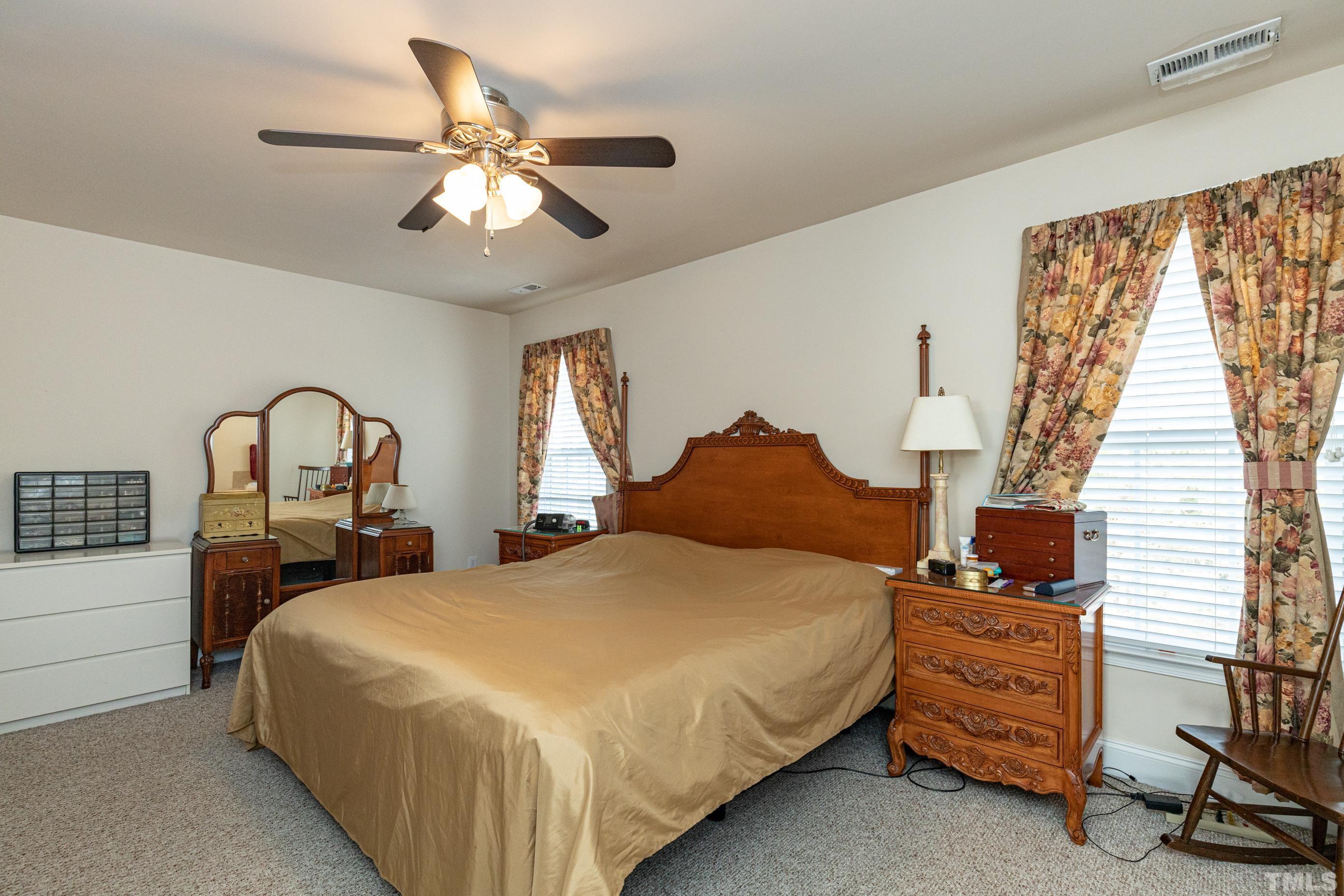 11210 Maplecroft Court Raleigh, NC 27617 - Photo 18 of 30 a bedroom with a bed and a chandelier