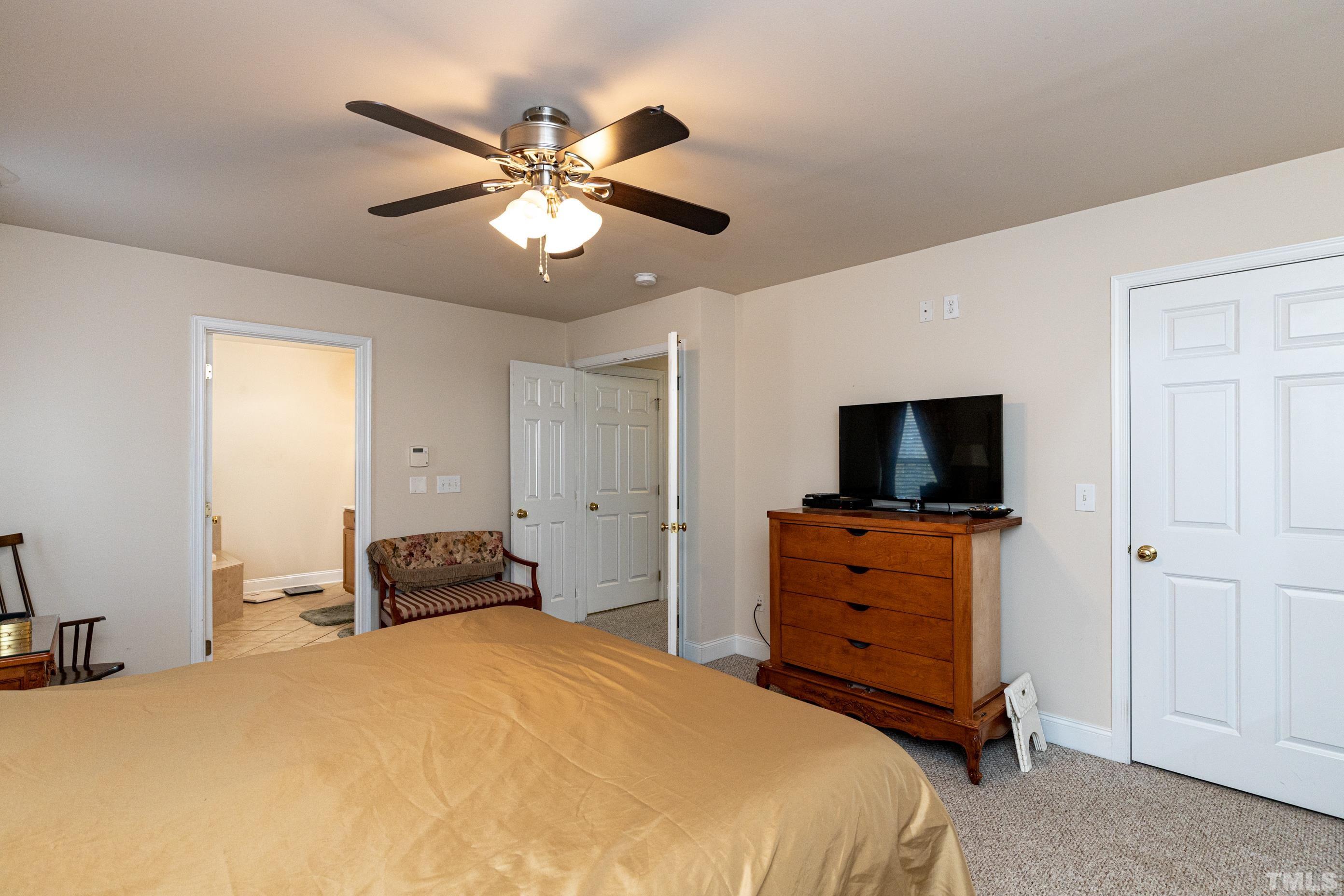 11210 Maplecroft Court Raleigh, NC 27617 - Photo 20 of 30 a bedroom with a bed and a flat tv screen on dresser
