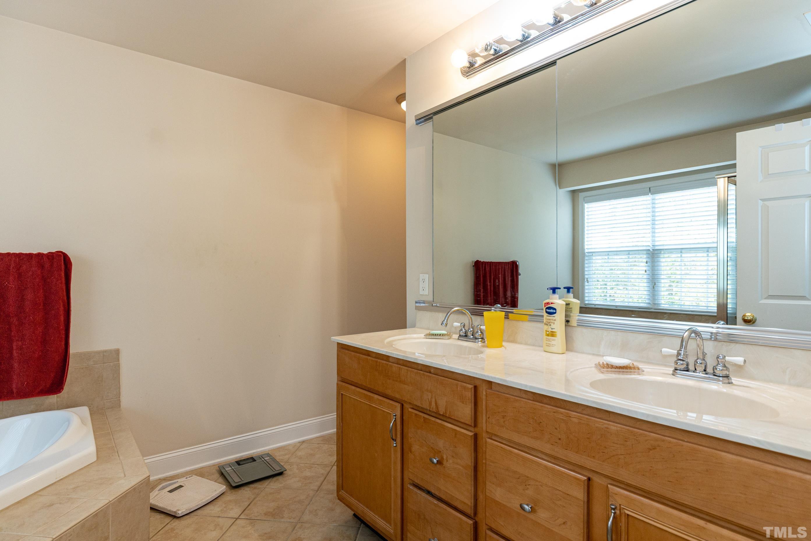 11210 Maplecroft Court Raleigh, NC 27617 - Photo 21 of 30 a bathroom with a sink mirror vanity and toilet