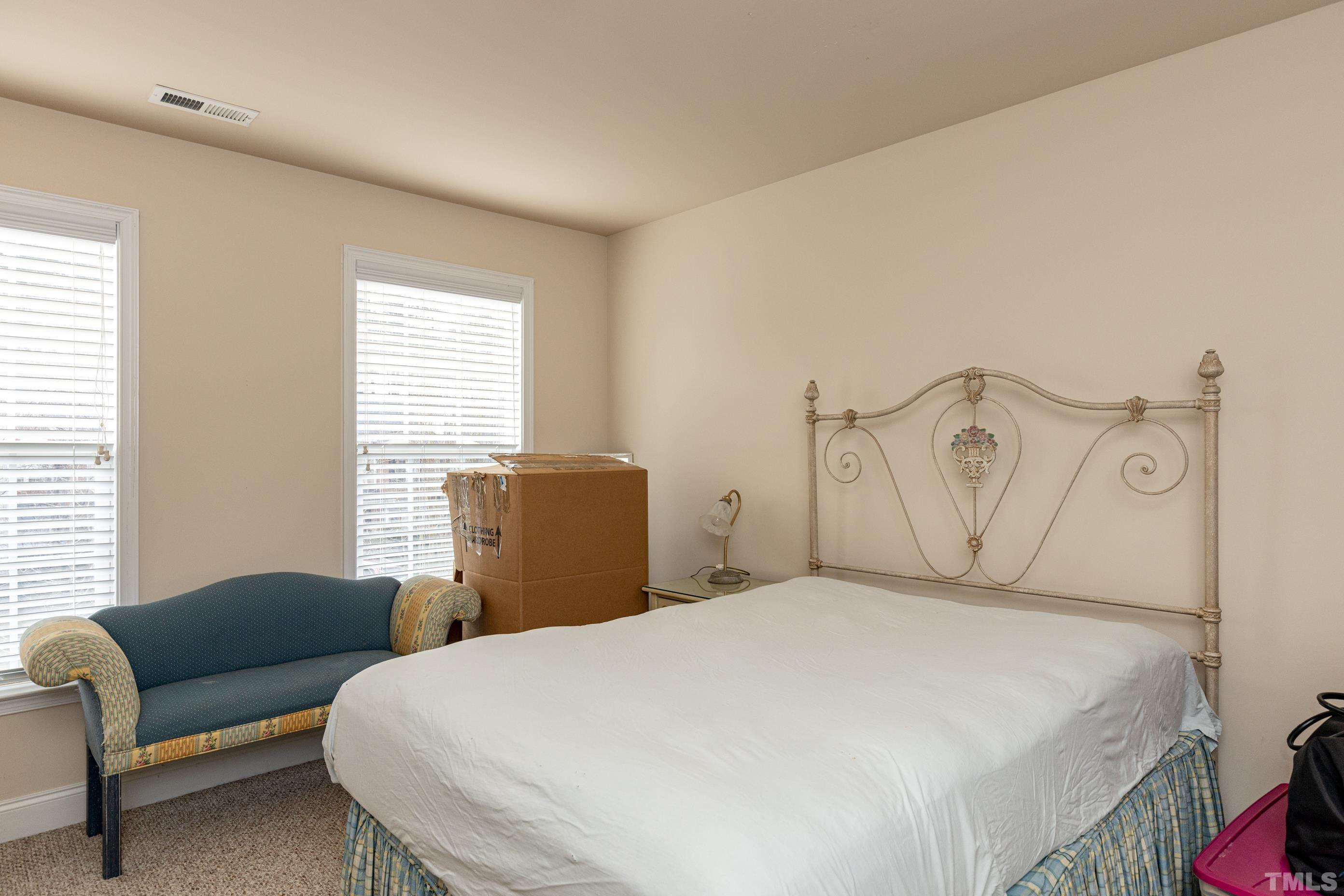 11210 Maplecroft Court Raleigh, NC 27617 - Photo 23 of 30 a bedroom with a bed a couch and a window