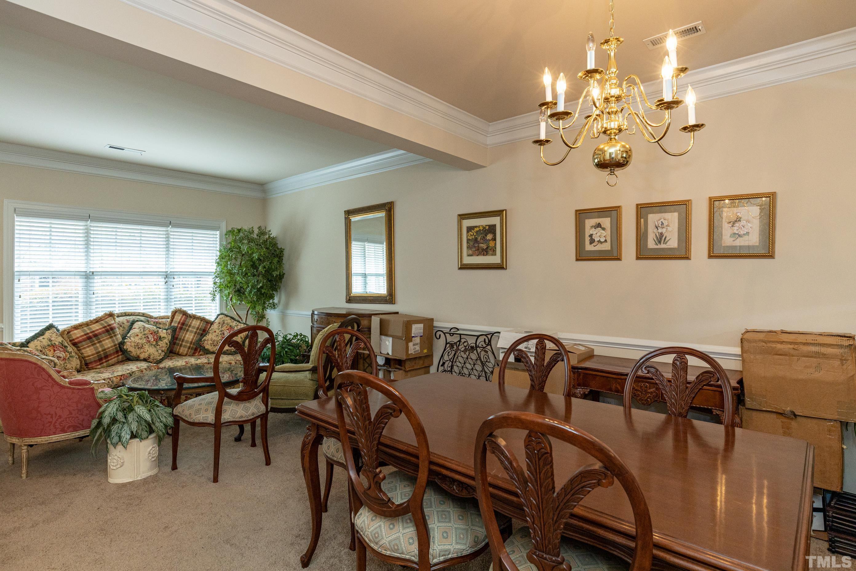 11210 Maplecroft Court Raleigh, NC 27617 - Photo 9 of 30 a living room with furniture a chandelier and a window