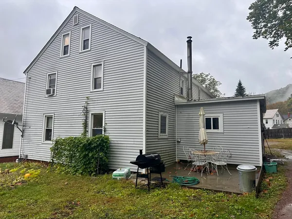 a backyard of a house with table and chairs