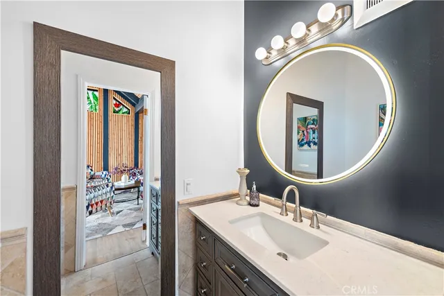 a bathroom with a granite countertop tub sink and glass door