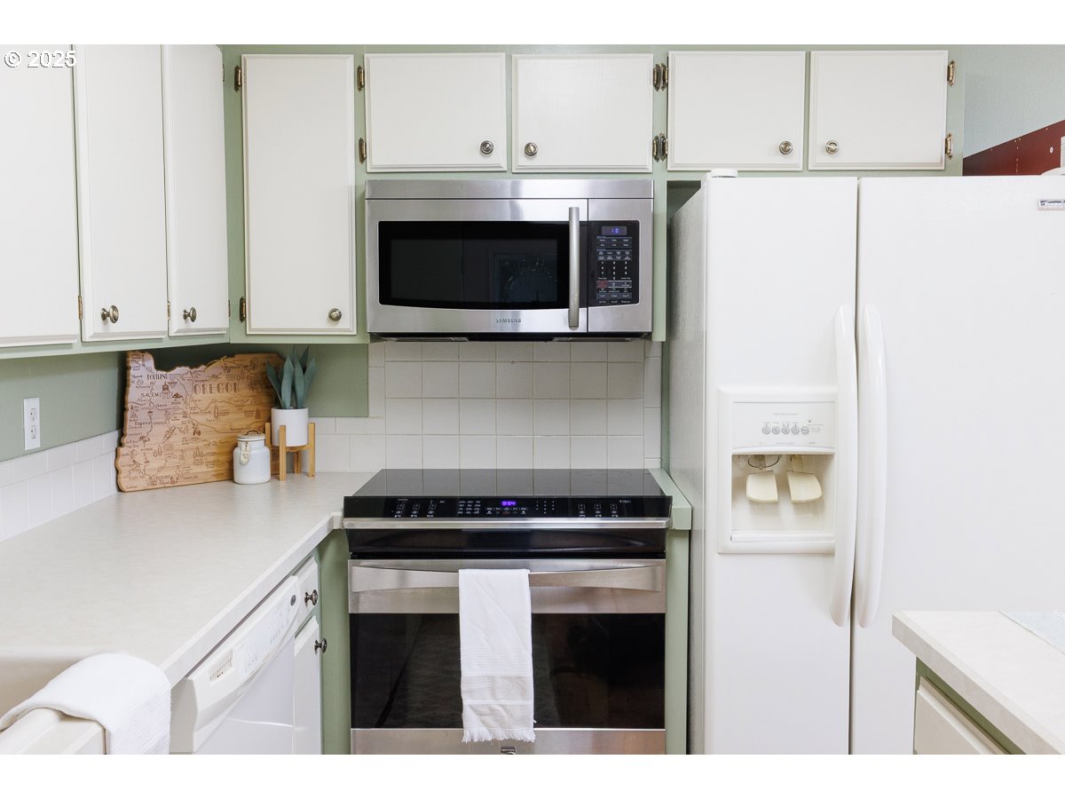 490 North Hayden Island Drive, Unit 98 Portland, OR 97217 - Photo 6 of 21 a kitchen with stainless steel appliances a white cabinet and a granite counter tops