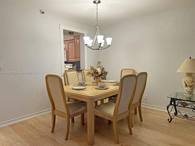 a dining room with furniture a chandelier and wooden floor