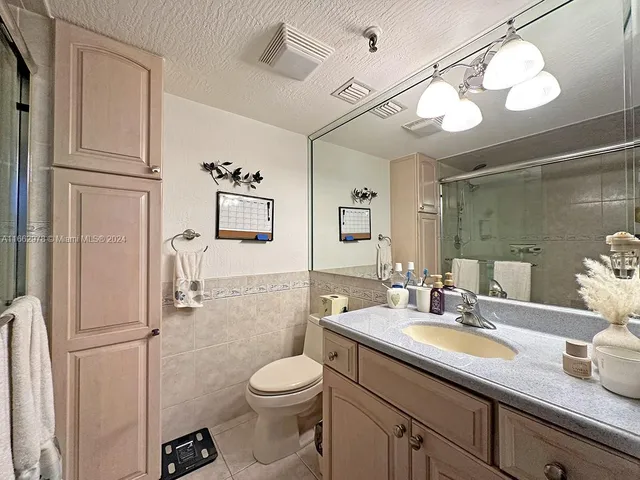 a bathroom with a toilet a sink and mirror