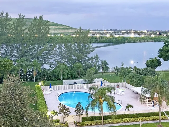 an aerial view of residential house with outdoor space and trees all around