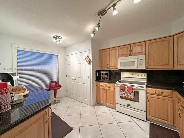 a kitchen with stainless steel appliances kitchen island granite countertop a stove a sink and a microwave